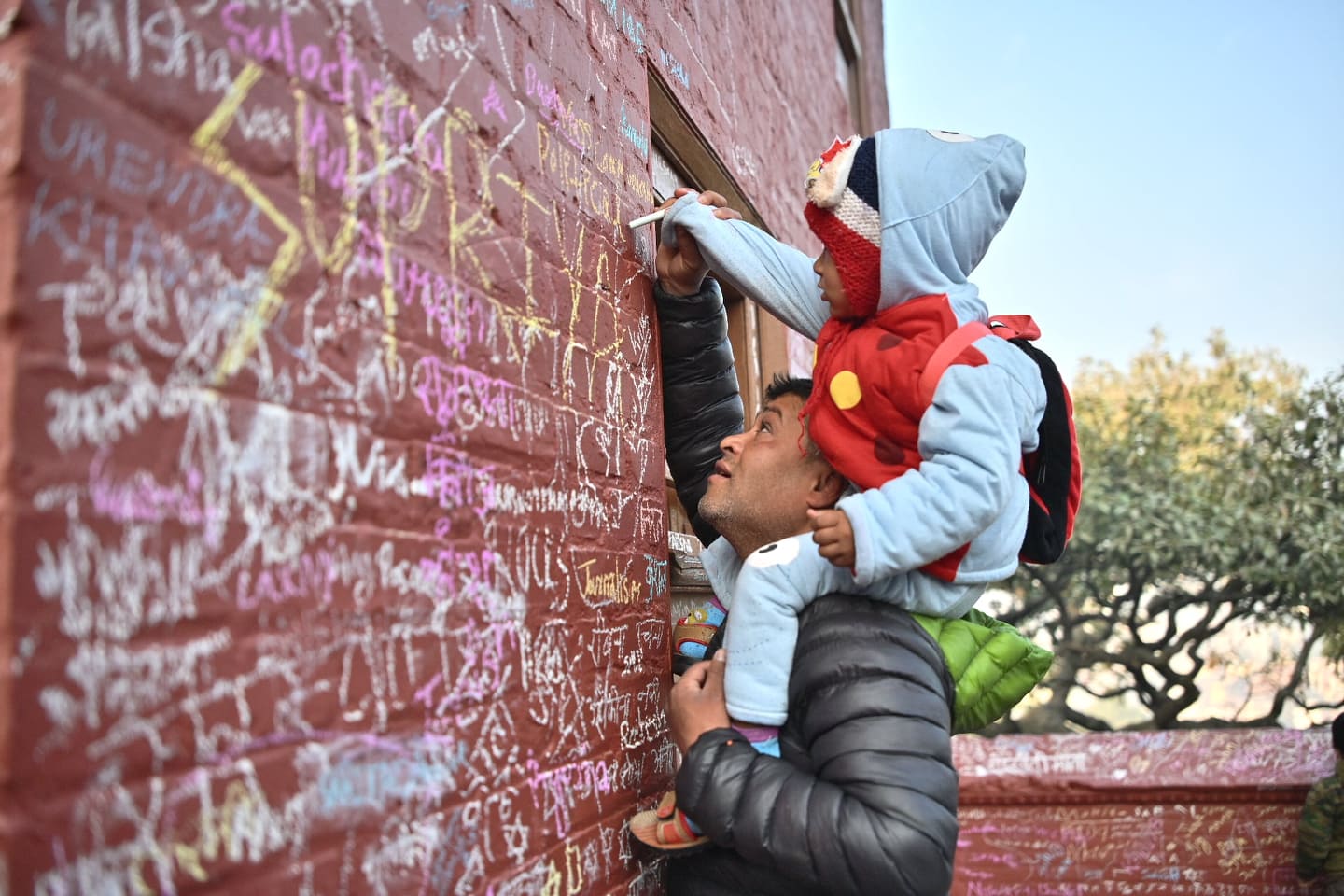 सरस्वती पूजामा बालबालिकालाई शिक्षा आरम्भ गराउँदै अभिभावक